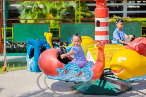 dos niños pequeños jugando en un patio de juegos en Whiterock Beach Hotel and Waterpark en Subic