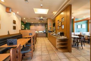 un restaurante con mesas y sillas y una cafetería en Pacific Hotel Shiroishi en Shiroishi
