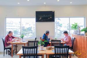 a group of people sitting at tables in a restaurant at Hồng Môn Resort Đà Lạt in Da Lat