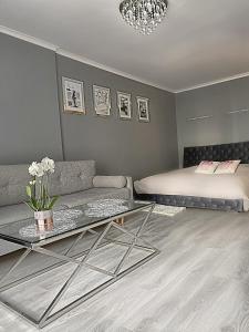 - un salon avec un canapé et un lit dans l'établissement Platinum Apartment przy plaży, z parkingiem, z dużym balkonem, à Sopot