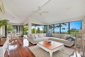a living room with a couch and a table at Tree Top Oasis in Buderim