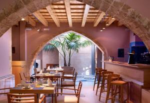 a restaurant with tables and chairs and a palm tree at Elia Fatma Boutique Hotel in Chania
