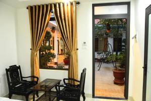 a room with a table and chairs and a window at Asean Garden Homestay Hue in Hue