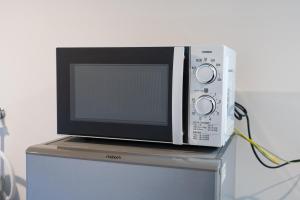a microwave oven sitting on top of a refrigerator at Tsukuyomi Higashiyama in Kanazawa