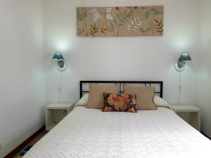 een slaapkamer met een wit bed en 2 nachtkastjes bij Casa da Quinta in Povoação