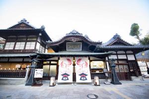 un edificio con una señal delante de él en Hotel Kajiwara, en Matsuyama