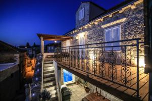 a house with a balcony at night at Dubrovnik-Cavtat Villa Mima -Sea front Villa with pool in Cavtat