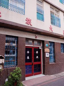 台南市にあるNeat Hostelの赤いドアと窓のある建物