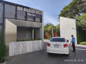 a police officer standing next to a white car in front of a building at D2 residences huahin 华欣市中心近海滩近商场酒店式公寓可加床有连通房型 in Hua Hin