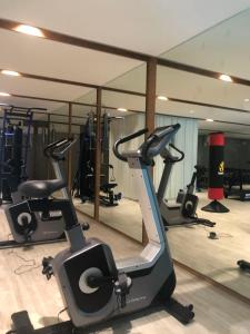 einen Fitnessraum mit mehreren Heimtrainern und einem Spiegel in der Unterkunft D2 residences huahin 华欣市中心近海滩近商场酒店式公寓可加床有连通房型 in Hua Hin