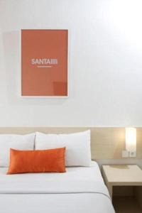 a bed with an orange pillow in a room at Zuri Express Lippo Cikarang in Cikarang