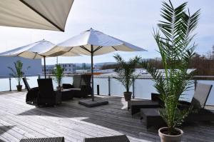 a patio with chairs and umbrellas on a deck at Apart-Hotel FirstBoarding Bayreuth in Bayreuth