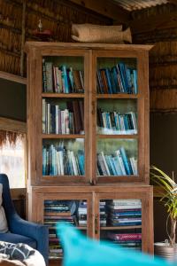 een boekenplank gevuld met boeken in een woonkamer bij Gugulesizwe Camp in Mabibi