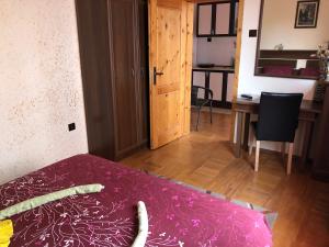 1 dormitorio con cama, mesa y escritorio en Guest House Dara, en Tsarevo