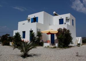 a white house with an umbrella in front of it at Theophili in Zefiría