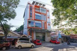 マナドにあるIstanaku Guesthouse 2の車が目の前に停まった高い建物