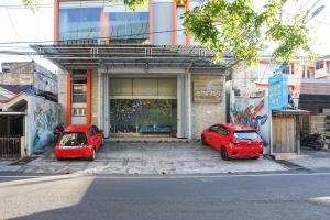 two red cars parked in front of a building at Istanaku Guesthouse 2 in Manado