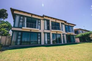 a large house with large windows and a yard at Castellon Boutique Hotel in Table View