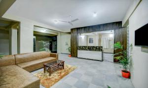 a living room with a couch and a tv at Treebo Trend Yash Inn Kharadi in Pune