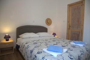 ein Schlafzimmer mit einem Bett mit blauen Handtüchern darauf in der Unterkunft Apartments Vila Mileva in Rava