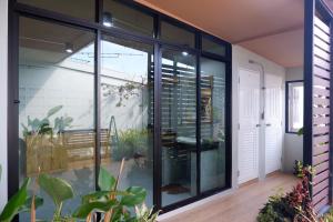 a room with large glass doors and plants at Otter House in Krabi