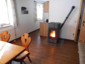 ein Wohnzimmer mit einem Kamin, einem Tisch und Stühlen in der Unterkunft Seewiesenalm in Reit im Winkl