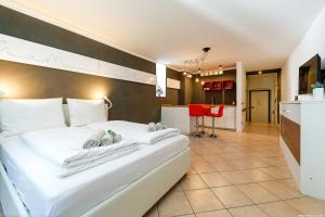 a hotel room with a white bed and a kitchen at Apartment Bolzano in Bolzano