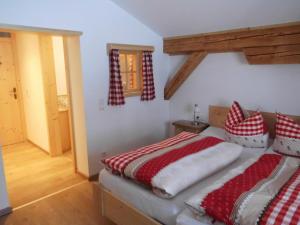 ein Schlafzimmer mit einem Bett mit roten und weißen Kissen in der Unterkunft Seewiesenalm in Reit im Winkl