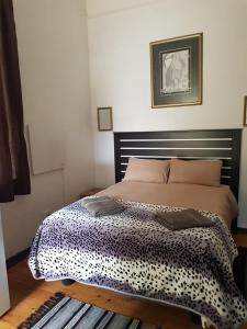 een slaapkamer met een bed met een zwart-witte deken bij Reis n Rus in Harrismith