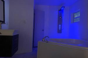 a blue room with a bath tub with a sink at Miami haven by airport in Miami