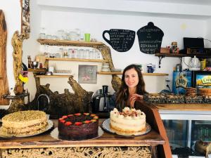 una mujer parada frente a una mesa con pasteles en Guest House Dara, en Tsarevo