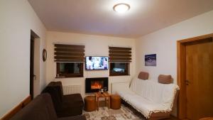 a living room with a white couch and a fireplace at Forest Dream Bjelasnica in Bjelašnica