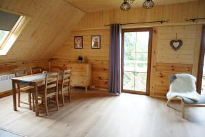 a dining room with a table and chairs and a window at Przystań Bieszczady in Zawóz
