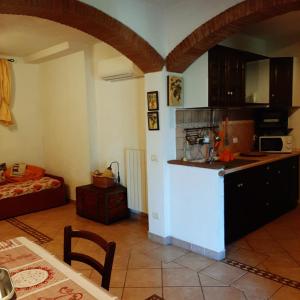 eine Küche und ein Wohnzimmer mit einem Tisch und einem Kühlschrank in der Unterkunft Le Case del Riccio - Isola d'Elba (049004LTN0006) in Capoliveri