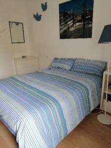 a bed with a striped blanket in a bedroom at Ichnussa in Udine