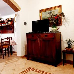 a living room with a television on a wooden cabinet at Le Case del Riccio - Isola d'Elba (049004LTN0006) in Capoliveri