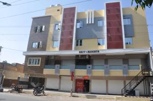 a building with two motorcycles parked in front of it at Hotel the grand shiva in Gondal