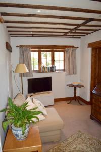 a living room with a couch and a tv at Norfolk Broads Bolthole in Stokesby