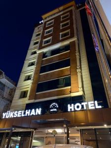 a hotel building with a sign on the side of it at Adana Yukselhan Hotel in Adana