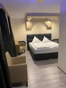 - une chambre avec un lit et une chaise dans l'établissement Hotel Ristorante Sicilia, à Tappenbeck