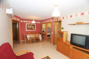a living room with a tv and a dining room at COSTA DAURADA APARTAMENTS - Larimar in Salou
