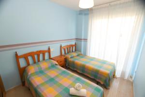 two twin beds in a room with a window at COSTA DAURADA APARTAMENTS - Larimar in Salou