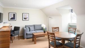 a living room with a couch and a table and chairs at voco Oxford Spires by IHG in Oxford +139 photos