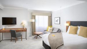 a hotel room with a bed and a desk at voco Oxford Spires by IHG in Oxford