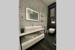 a bathroom with a white sink and a toilet at MOHO Residences Korçë in Korçë +6 photos