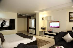 a bedroom with a bed and a tv in it at Kingdom Hotel in Moga