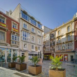 a group of buildings in a street with potted plants at San Sebastian Suites in Cartagena