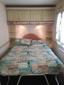 a bed in a small room with a large bed at Three bedroom Hartland Caravan in Bideford