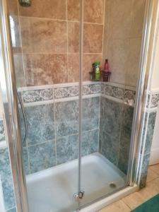 a shower with a glass door in a bathroom at Ambles in Northampton