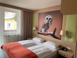 フィヒテルベルクにあるWAGNERS Hotel Schönblick, C&C Hotels und Vertrieb GmbHのフクロウの絵画が壁に描かれたベッドルーム